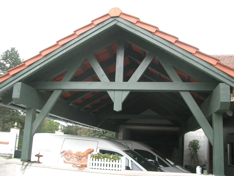Carport mit grün gestrichener Holzkonstruktion und Giebeldach