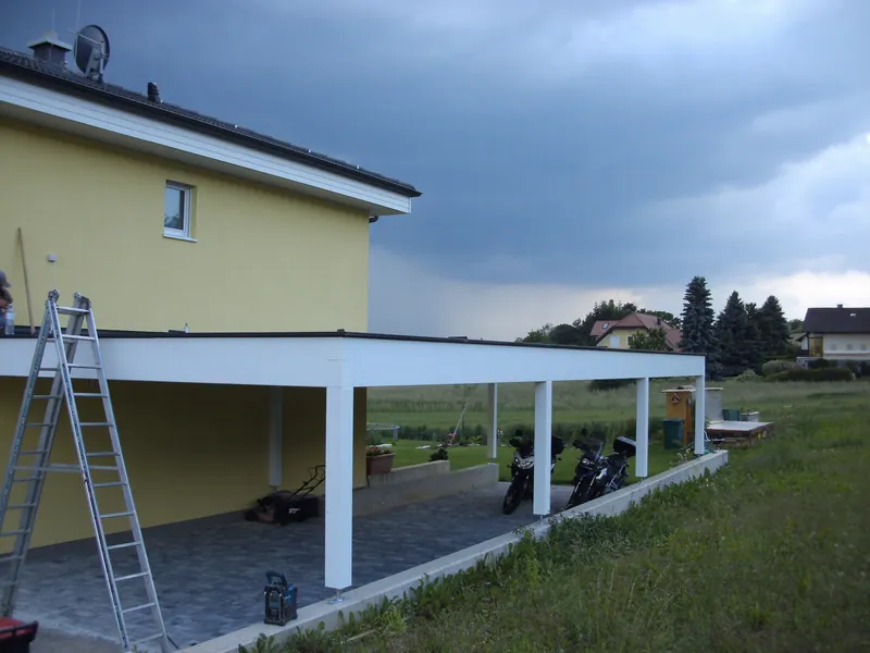 Weiß gestrichene Überdachung entlang eines Wohnhauses