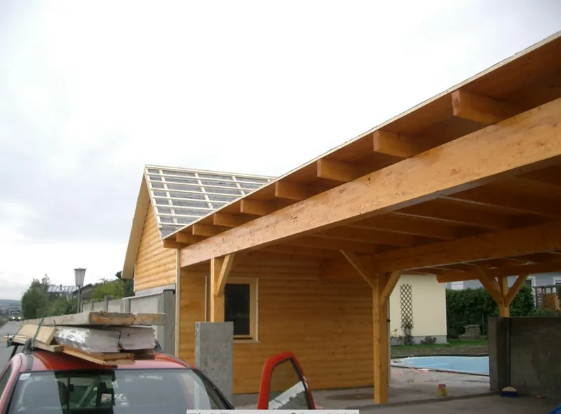 Carport aus Holz im Aufbau, die Dacheindeckung wird montiert