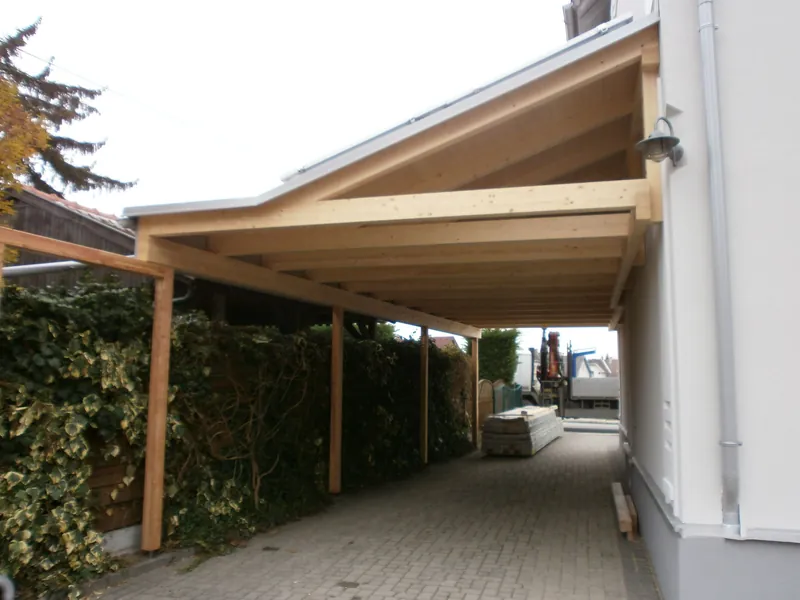 Schmaler Carport an einer Hauswand mit Holzkonstruktion