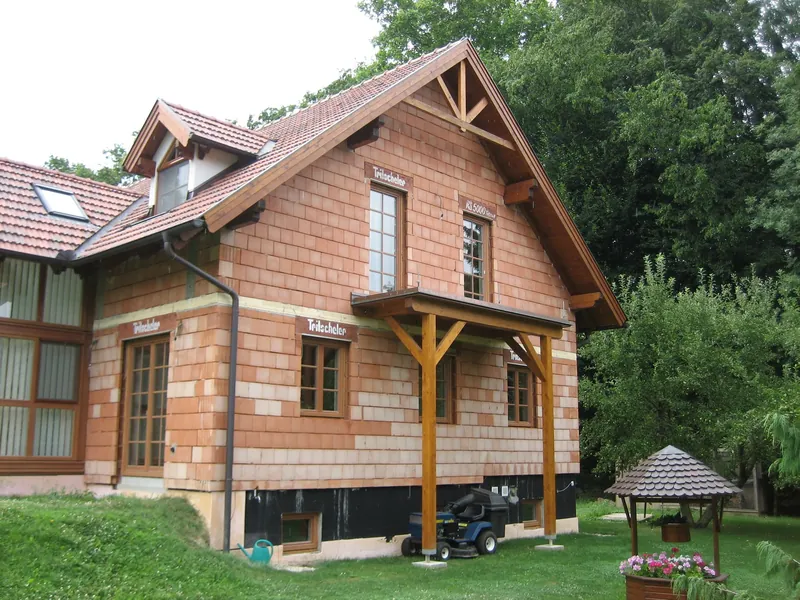 Ziegelhaus mit Satteldach und Holzvorbau
