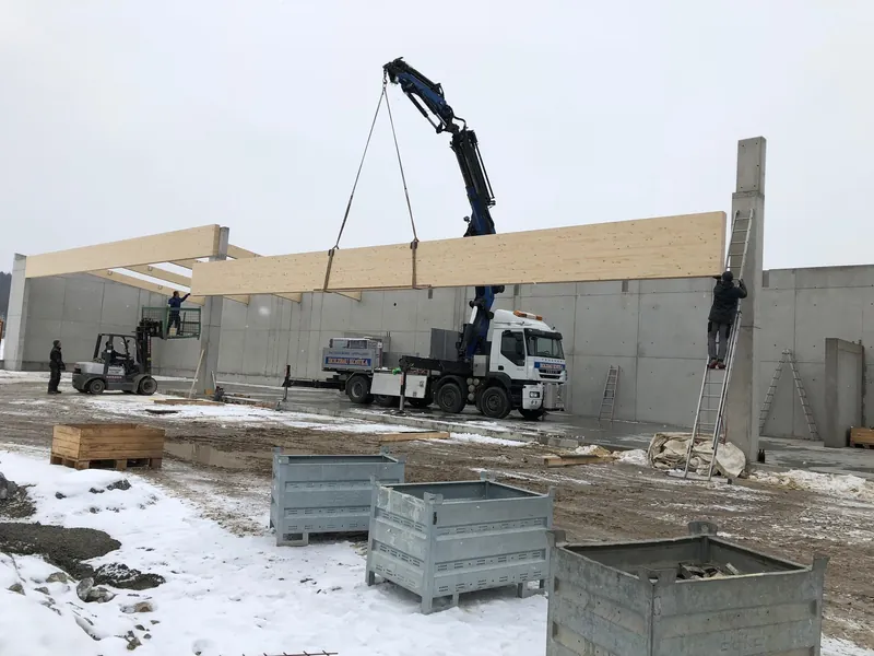 Kran und Holzträger bei der Hallenmontage