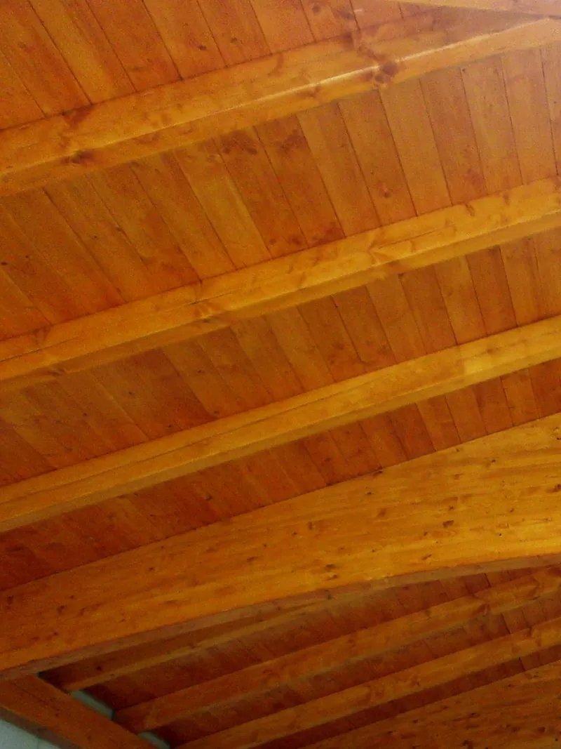 Holzdecke mit sichtbaren Balken in warmem Holzton