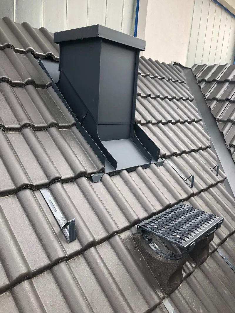 Kamin mit Blechverkleidung auf einem Ziegeldach