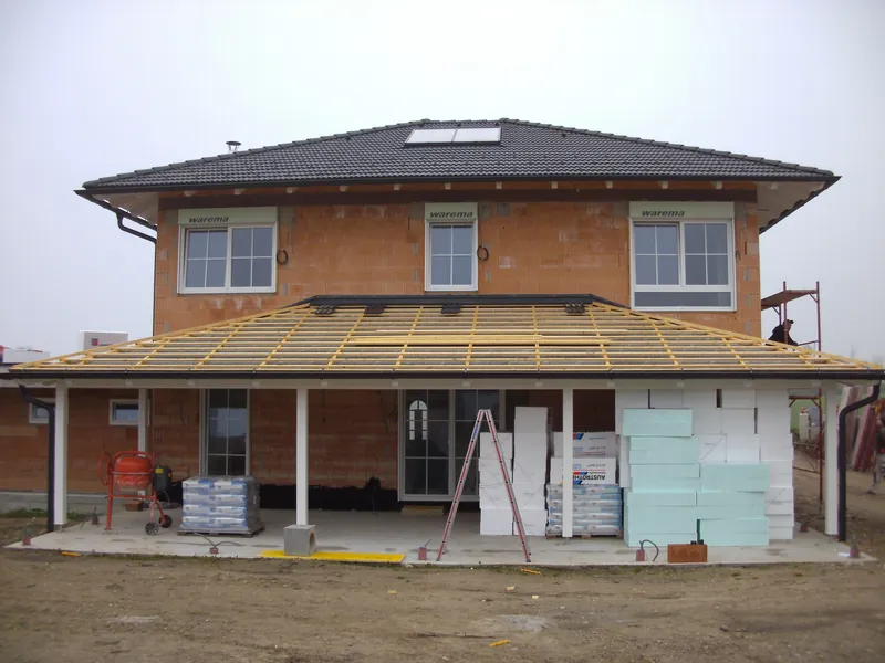 Haus mit überdachter Terrasse und Holzsäulen