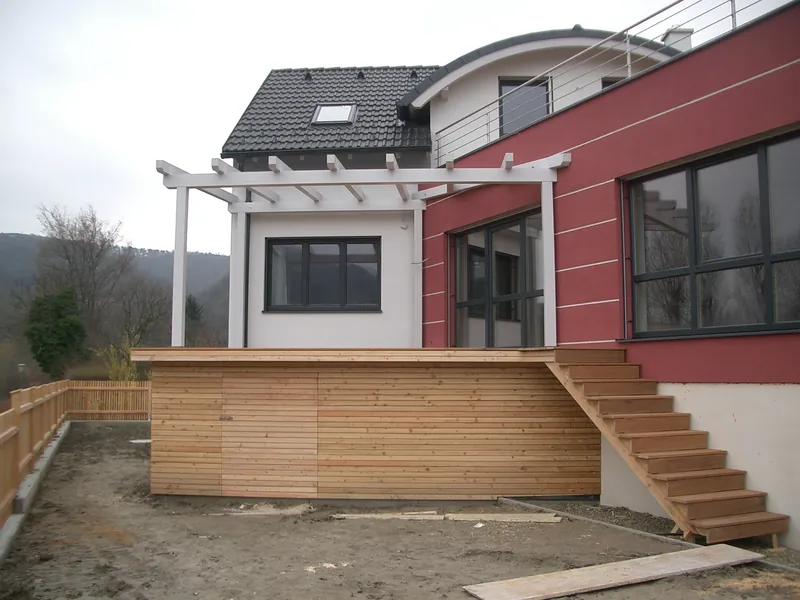 Holzterrasse mit Treppe und weißer Pergola