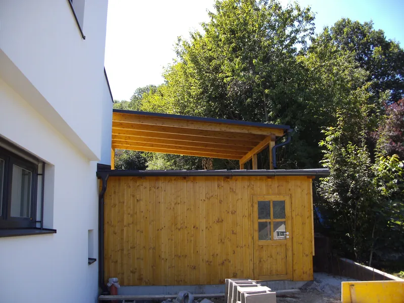 Gartenhaus aus Holz mit Pultdach an einer Hauswand