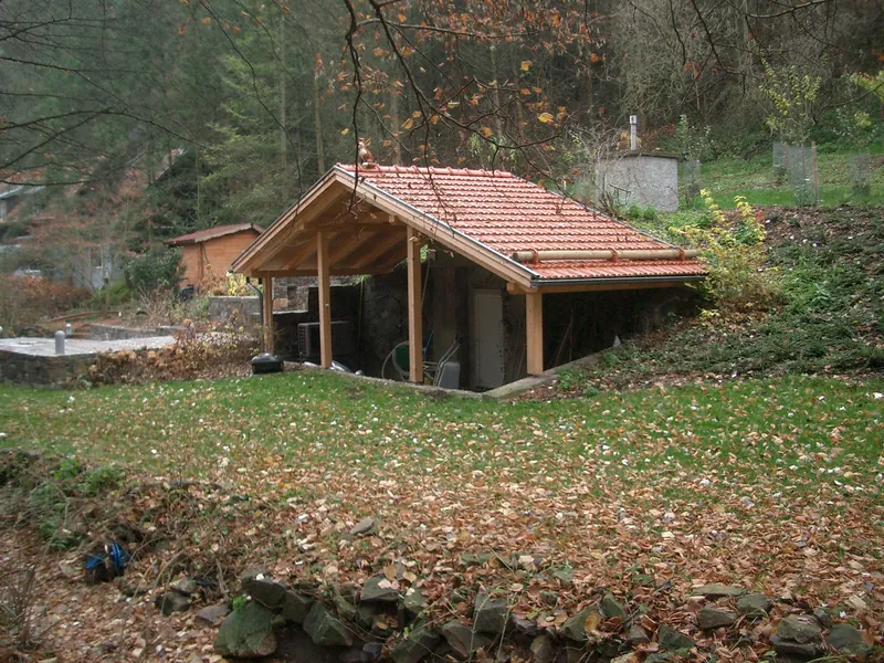 Kleines Holzgebäude mit Ziegeldach in Hanglage