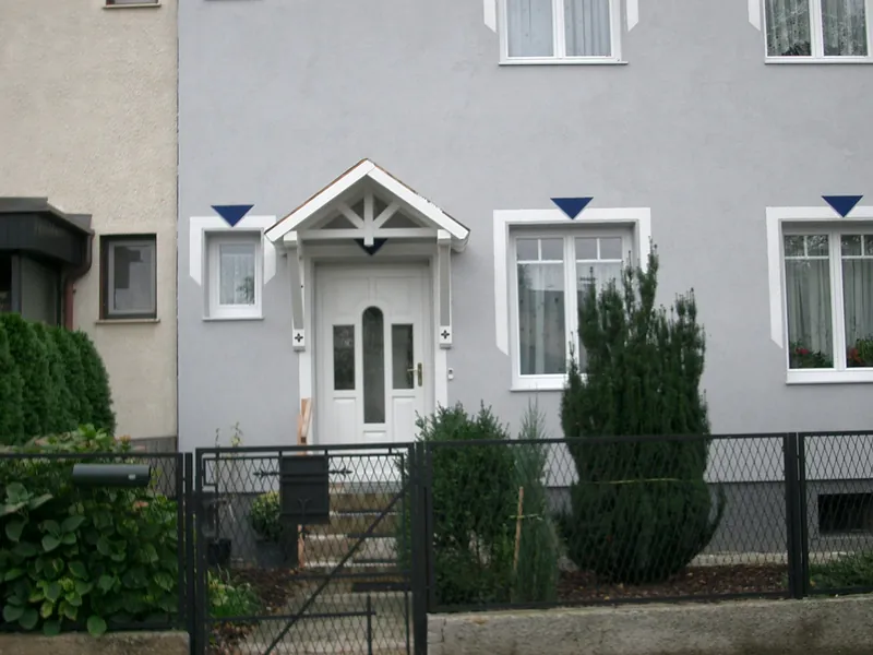 Weißes Vordach mit Giebel über einer Haustür